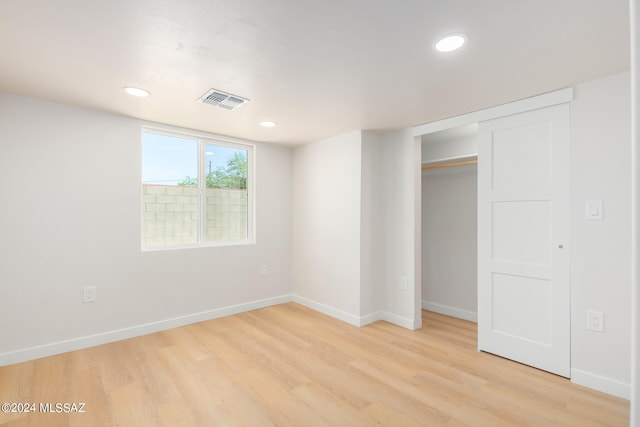 unfurnished bedroom with a closet and light hardwood / wood-style floors