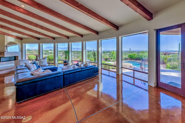 living room with a mountain view, beamed ceiling, and concrete flooring