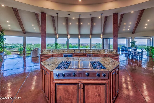 kitchen with a skylight, light stone countertops, a sink, beverage cooler, and built in appliances