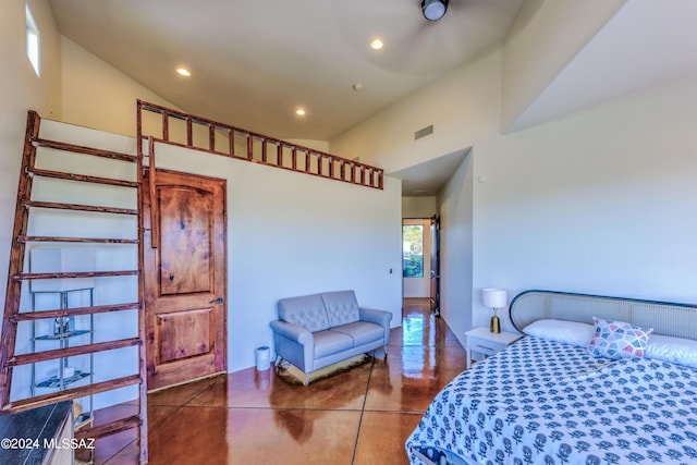 bedroom with high vaulted ceiling and concrete flooring