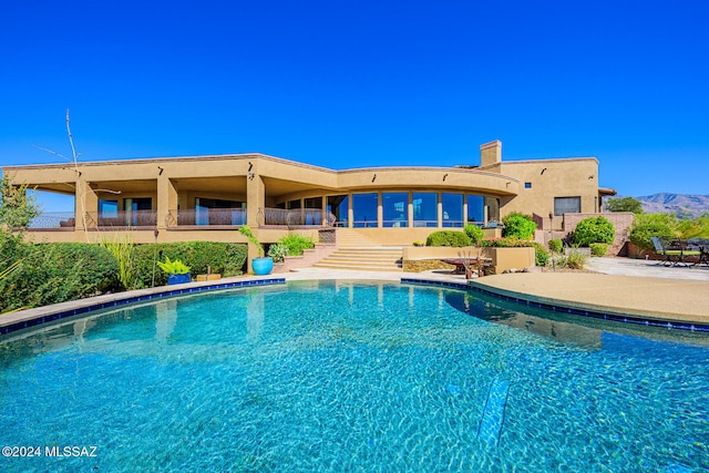 view of swimming pool with a mountain view and a patio