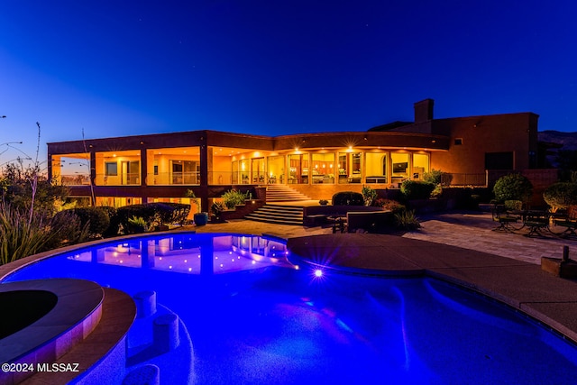 pool at dusk with a patio