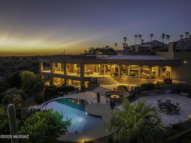 outdoor pool with stairs and a patio area