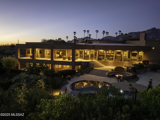 mediterranean / spanish-style home featuring decorative driveway, an attached garage, fence private yard, and stucco siding