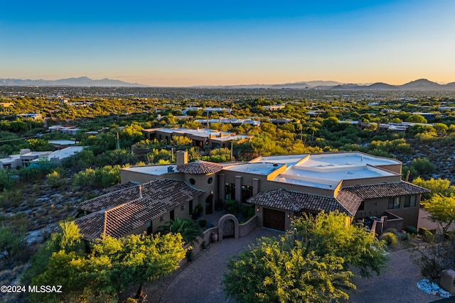 aerial view at dusk featuring a mountain view