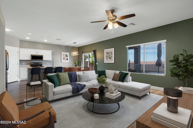 living room with hardwood / wood-style flooring and ceiling fan