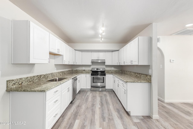 kitchen featuring light wood-type flooring, light stone countertops, stainless steel appliances, and white cabinets