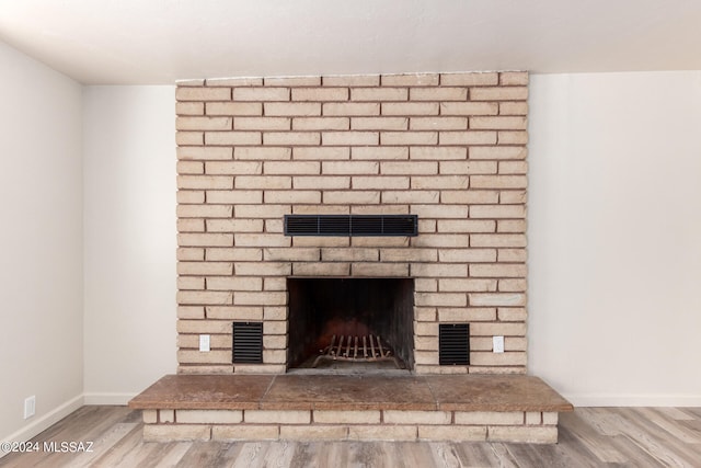 room details with hardwood / wood-style flooring and a brick fireplace