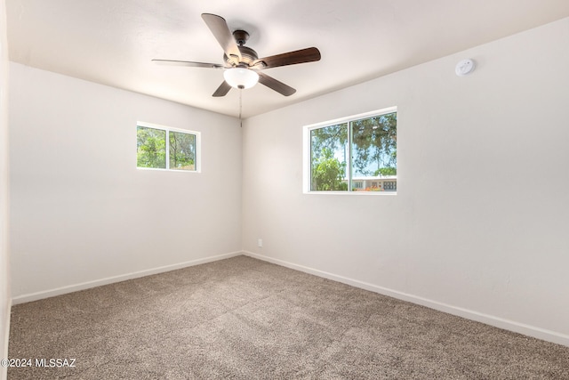 carpeted empty room featuring ceiling fan and a wealth of natural light