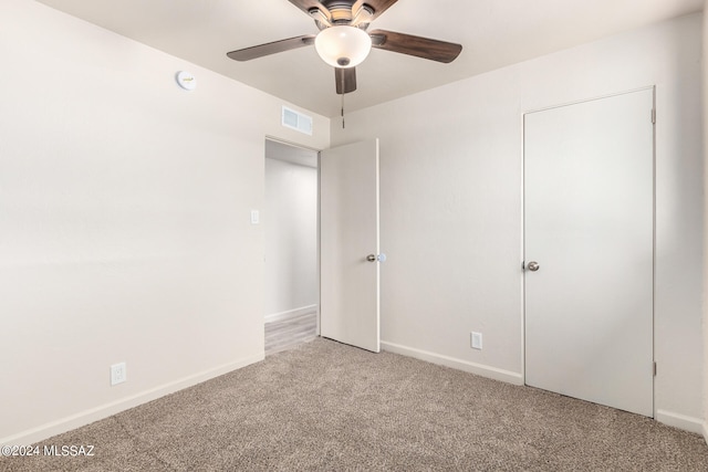 unfurnished bedroom with ceiling fan and light colored carpet