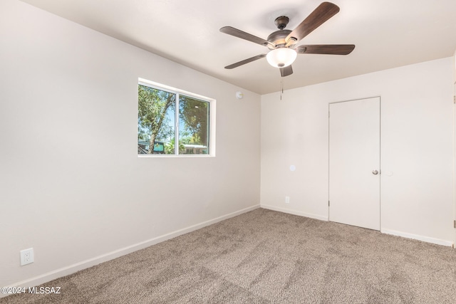 carpeted spare room with ceiling fan