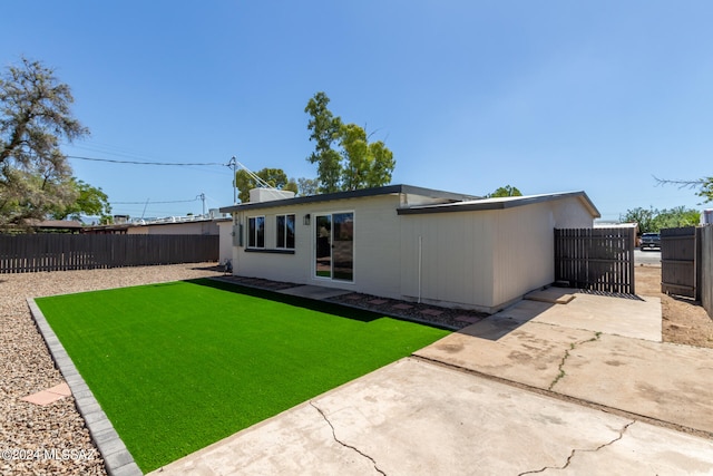 back of property with a patio area and a yard