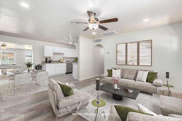 living room with light hardwood / wood-style floors and ceiling fan