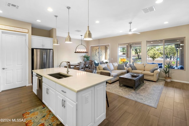 kitchen with white cabinets, sink, a kitchen island with sink, ceiling fan with notable chandelier, and dark hardwood / wood-style flooring