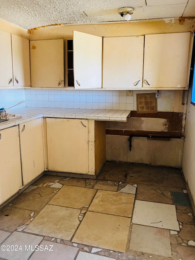 kitchen with backsplash and cream cabinetry