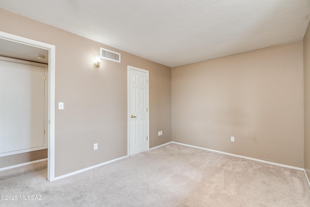 unfurnished bedroom with light carpet and a closet