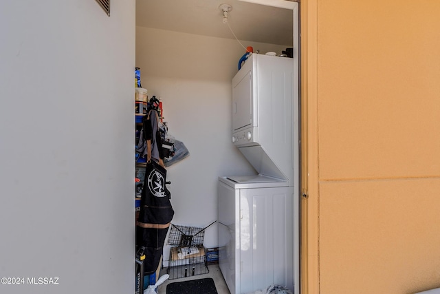 clothes washing area featuring stacked washing maching and dryer