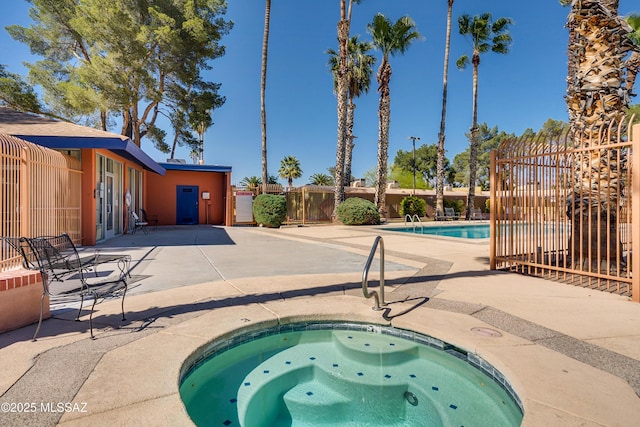 view of pool with a patio and a hot tub