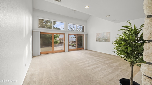 unfurnished living room featuring light colored carpet and a high ceiling