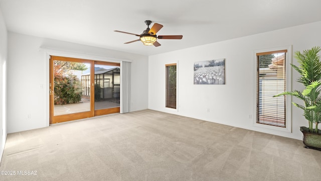 empty room with light carpet, plenty of natural light, and ceiling fan