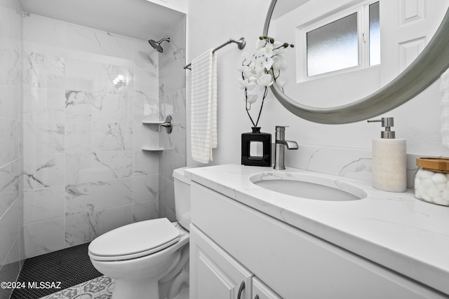 bathroom featuring vanity, toilet, and a tile shower