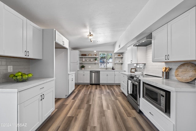 kitchen featuring appliances with stainless steel finishes, lofted ceiling, white cabinets, and backsplash