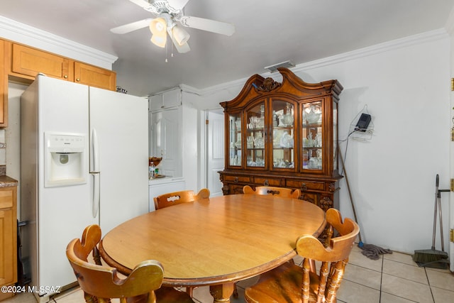 dining space with crown molding, ceiling fan, and light tile patterned floors