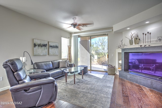 living room featuring ceiling fan and dark hardwood / wood-style flooring