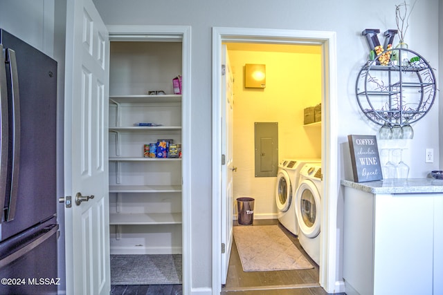 laundry area featuring electric panel, washer and dryer, and hardwood / wood-style floors