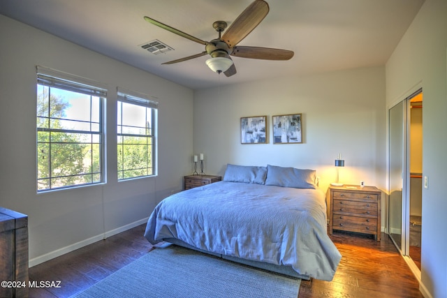 bedroom featuring ceiling fan, dark hardwood / wood-style floors, and a closet