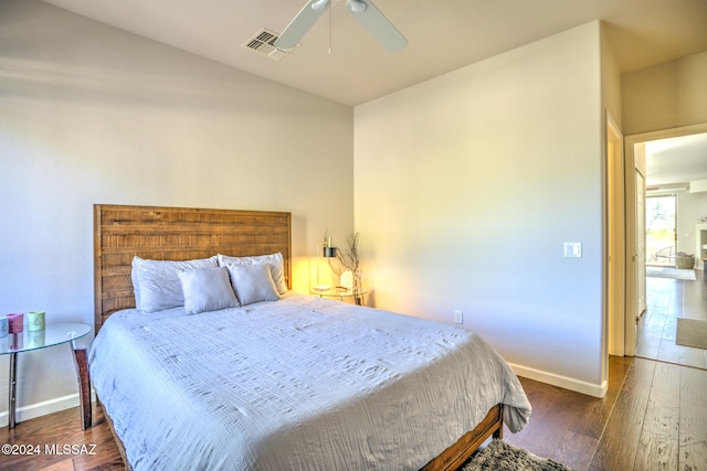 bedroom with dark hardwood / wood-style flooring and ceiling fan