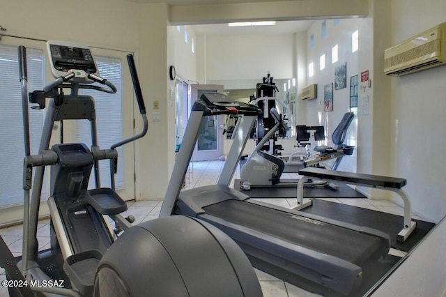 workout area featuring a wall unit AC and light tile patterned flooring