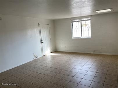 unfurnished room featuring tile patterned floors and baseboards