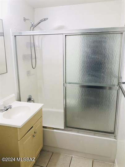 bathroom with enclosed tub / shower combo, vanity, and tile patterned flooring