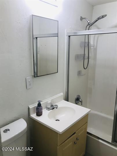 full bath with toilet, vanity, and enclosed tub / shower combo