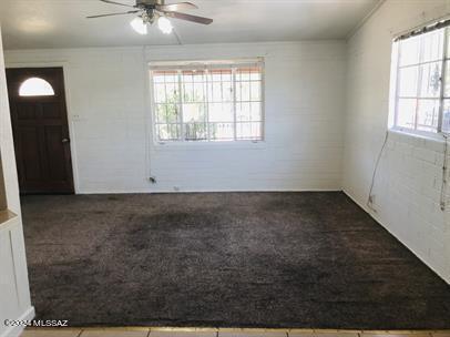 empty room with ceiling fan and carpet