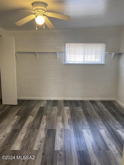 spare room featuring dark wood-type flooring and ceiling fan