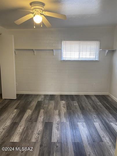 interior space with wood finished floors, ceiling fan, baseboards, and a closet