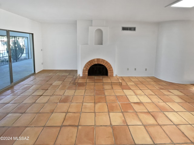 unfurnished living room with light tile patterned flooring and a fireplace