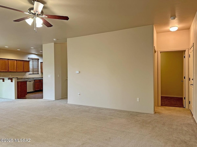 unfurnished living room featuring ceiling fan and light carpet