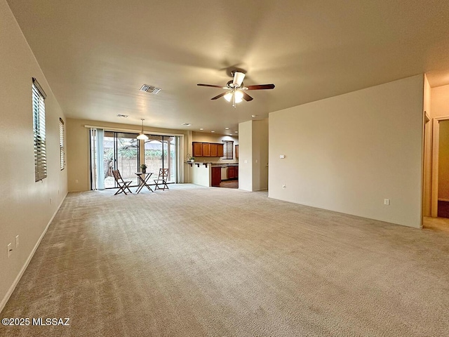 unfurnished living room featuring ceiling fan and light carpet