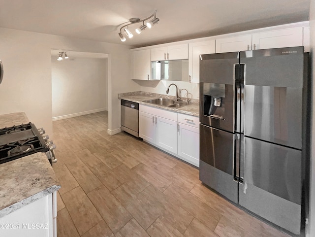 kitchen with stainless steel appliances, light wood-type flooring, sink, and white cabinetry