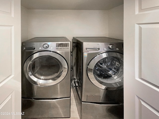 laundry area featuring washing machine and dryer and light tile patterned floors