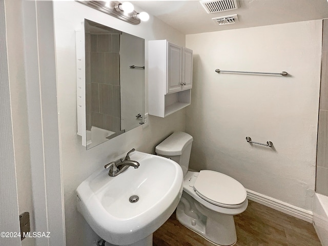 bathroom with hardwood / wood-style flooring, sink, and toilet