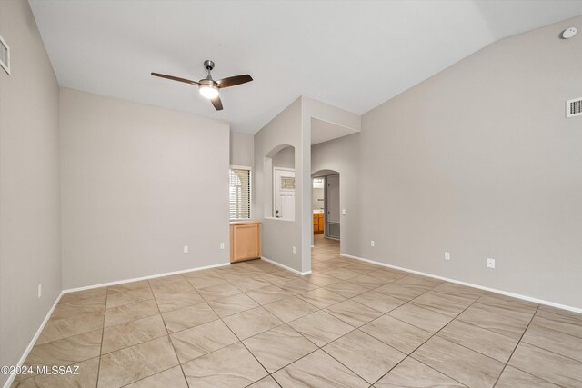 empty room featuring lofted ceiling and ceiling fan