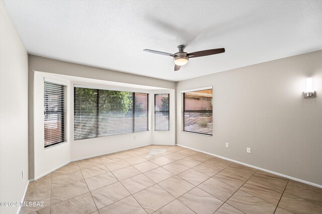 unfurnished bedroom with ceiling fan and a textured ceiling