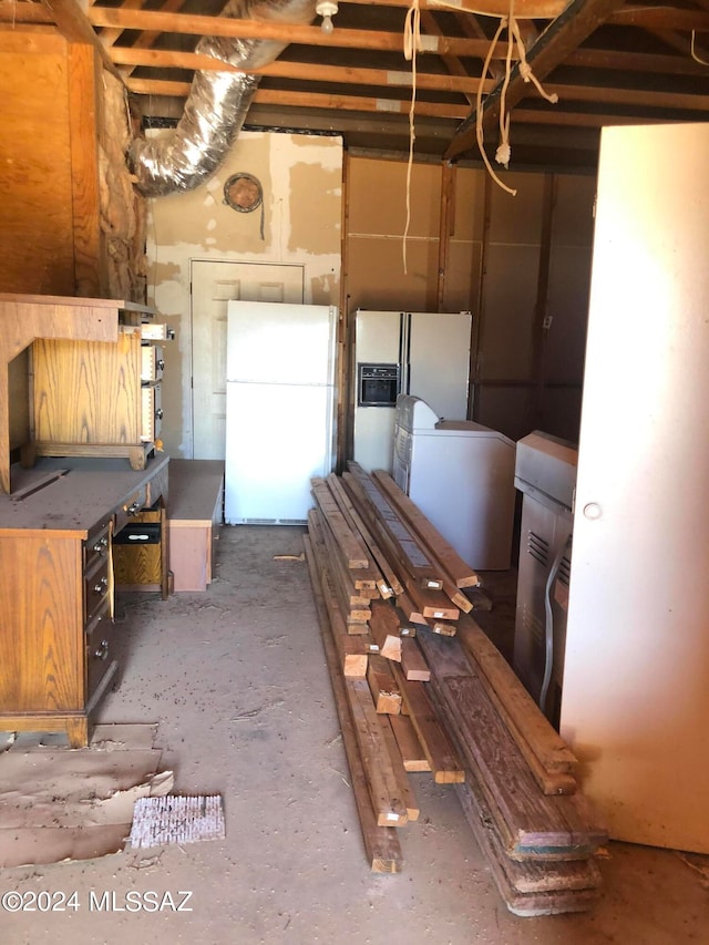 basement featuring white refrigerator with ice dispenser and white fridge