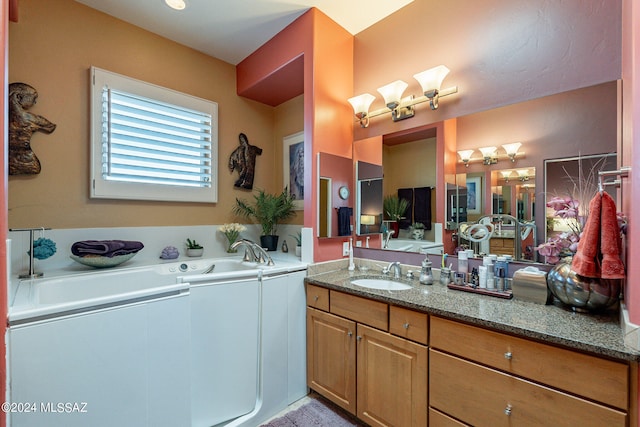 bathroom featuring vanity and a bath