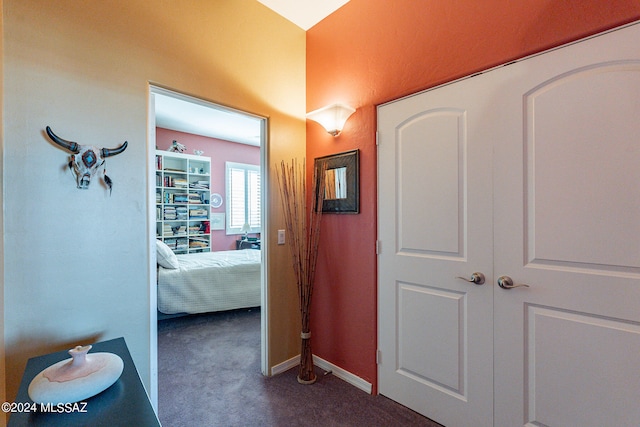 hallway featuring dark colored carpet