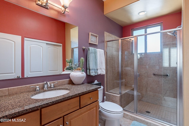 bathroom featuring tile patterned flooring, vanity, toilet, and an enclosed shower